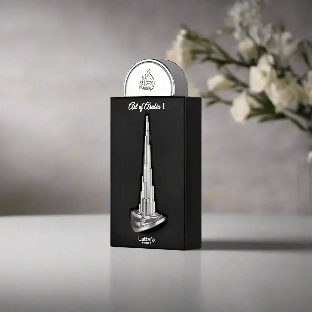 Schwarzer Parfumflakon mit silberner Verzierung und Art of Arabia I Aufschrift, Blumen im Hintergrund.