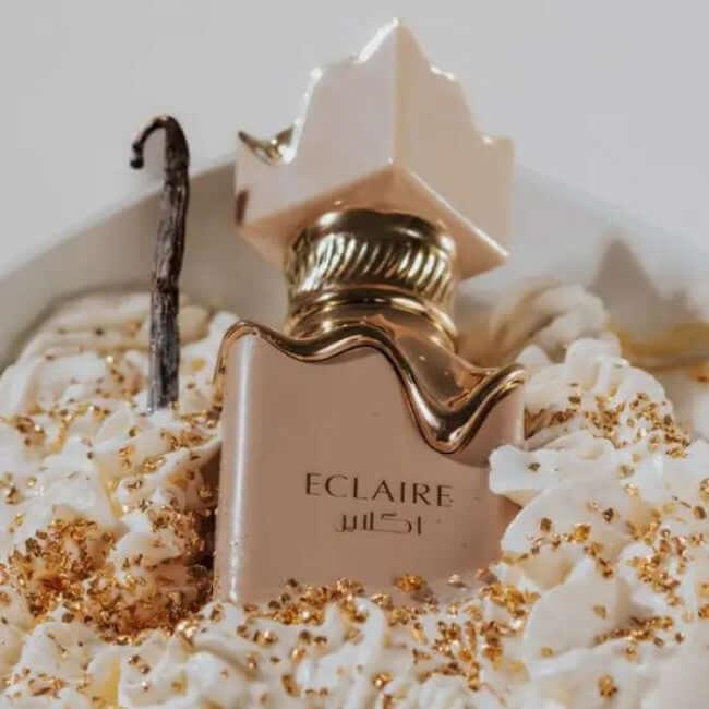 Edles Eau de Parfum ECLAIRE, 100 ml, vor Sahnehäubchen und Goldstreuseln dekorativ platziert
