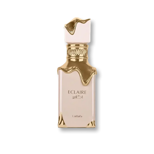 Luxuriöses Parfum Eclaire Flakon in Gold und Creme mit elegantem Design vor grünem Hintergrund